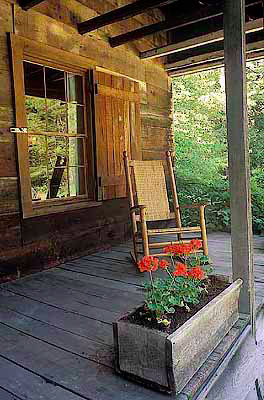 NC: Transylvania County, Pisgah National Forest, Davidson River Area, The Cradle of Forestry In America, Front porch of log cabin; begonias, rocking chair [Ask for #212.207.]