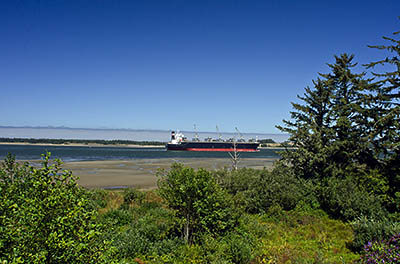 OR: South Coast Region, Coos County, Coos Bay Area, City of Coos Bay, Empire District, A ship enters Coos Bay to pick up a load of logs, as viewed from the bluffs south of the village's center [Ask for #271.121.]