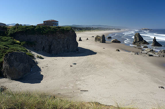 OR: Coos County, Bandon Area, South Beaches, Face Rock State Wayside, House sits atop sheer rock cliffs with a wide sandy beach below, spotted with large hoodoos [Ask for #274.356.]