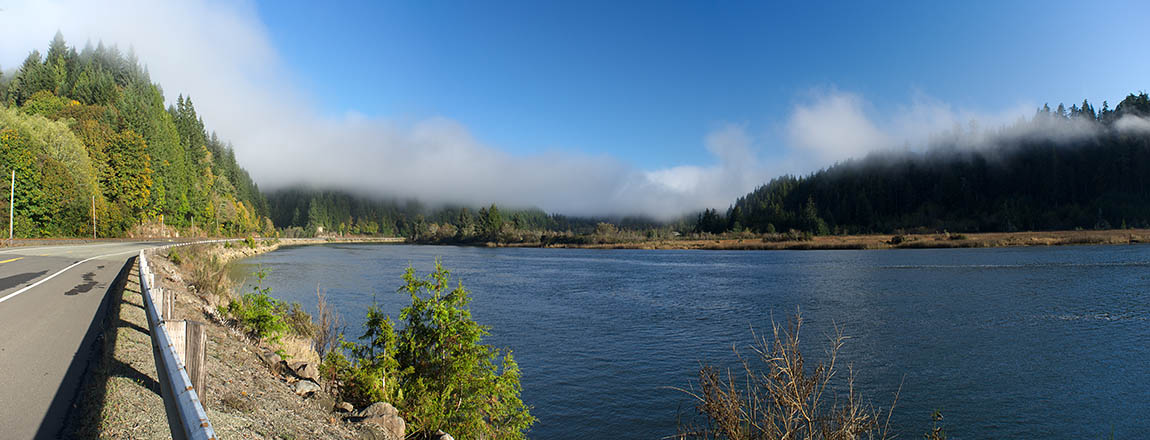 OR: South Coast Region, Douglas County, Coast Range, Smith River Area, Lower Smith River, The Smith River Road hugs the tidal inlet at the mouth of Smith River, with panoramic views; fog. [Ask for #276.004.]