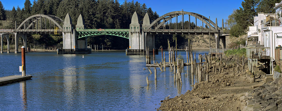 OR: South Coast Region, Lane County, Pacific Coast, Florence Area, Town of Florence, US 101 bridge over the Suislaw River inlet, a concrete arch structure with Art Deco details, by Conde McCollough, from the waterfront. [Ask for #276.467.]