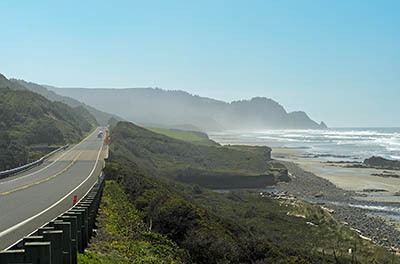 OR: South Coast Region, Lane County, Pacific Coast, Cape Perpetua Area, Roosevelt Beach, US 101 runs along sea cliffs; Rocky Knoll in background. [Ask for #276.507.]