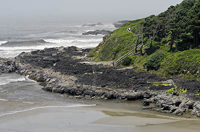 OR: South Coast Region, Lane County, Pacific Coast, Cape Perpetua Area, Cape Perpetua National Scenic Area, Cooks Chasm Viewpoint, A path descends on stairs to a sandy beach in a remote cove, as fog rolls in [Ask for #276.A42.]